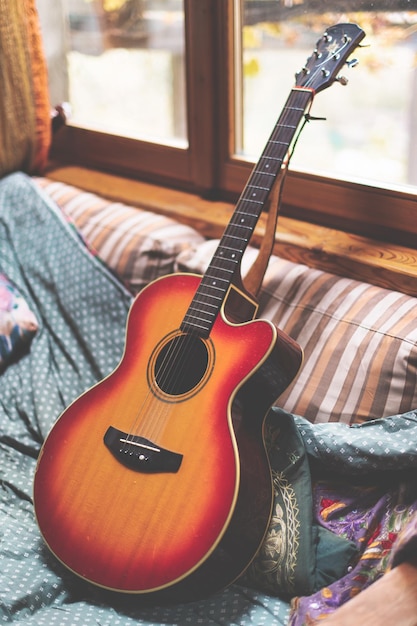 Akustikgitarre, die nach dem Spielen auf einem Sofa ruht