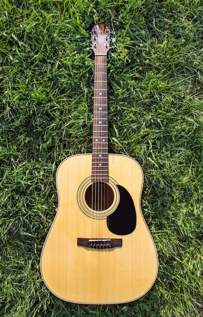 Foto akustische gitarre auf dem gras isoliert