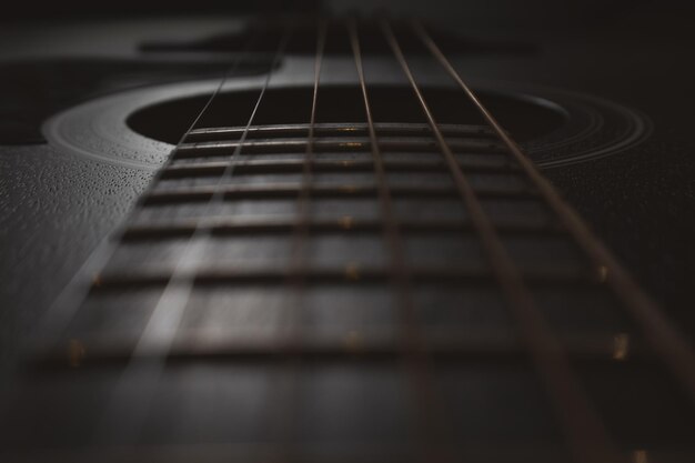 Foto akustische gitarre nahaufnahme selektiver fokus sichtbare halssaiten soundboard-resonator