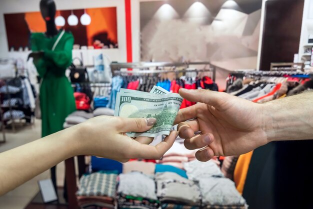 Foto al comprar ropa en la tienda, el comprador paga dinero por la compra. estilo de vida