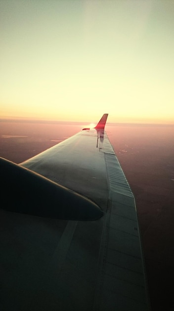 Foto ala de la aeronave contra un cielo despejado durante la puesta de sol