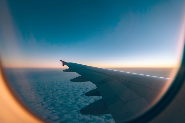 Ala de avión con amanecer en destello de luz