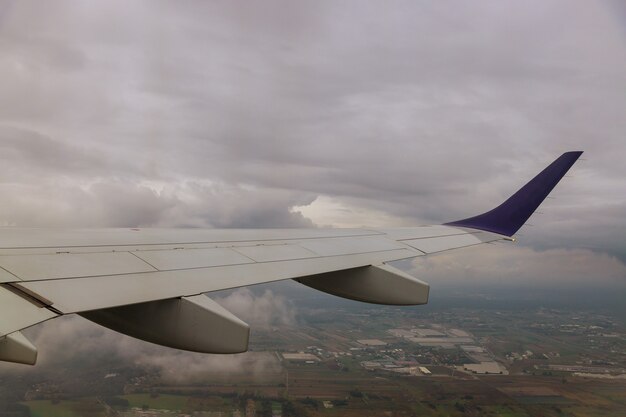 Ala de avión de avión volando por encima de las nubes en el cielo vista por la ventana en el cielo nublado