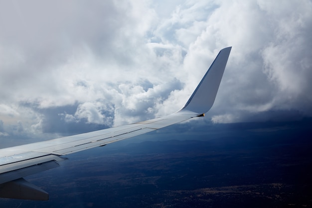 Ala de avión en un cielo nublado de nubes tormentosas