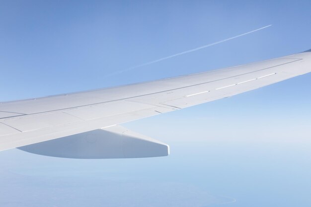 Foto el ala del avión contra el cielo azul claro