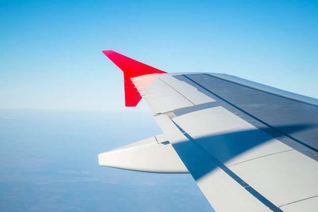 Ala de un avión que volaba por encima de las nubes de la mañana.