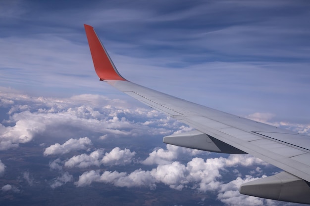 El ala de un avión volador contra el fondo de las nubes