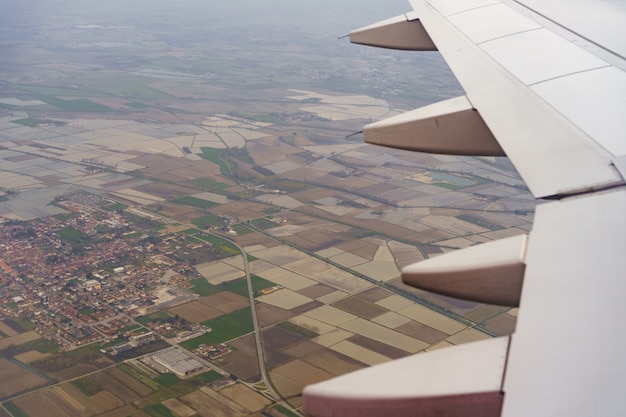 Ala de avión volando en el cielo sobre campos y casas