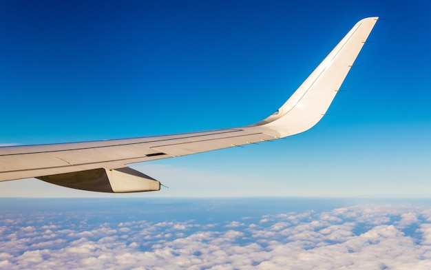 Un ala de avión volando en el cielo sobre las nubes.