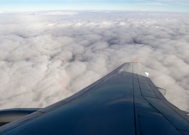 Ala de avión en vuelo bajo las nubes sobre la ciudad de Moscú en Rusia