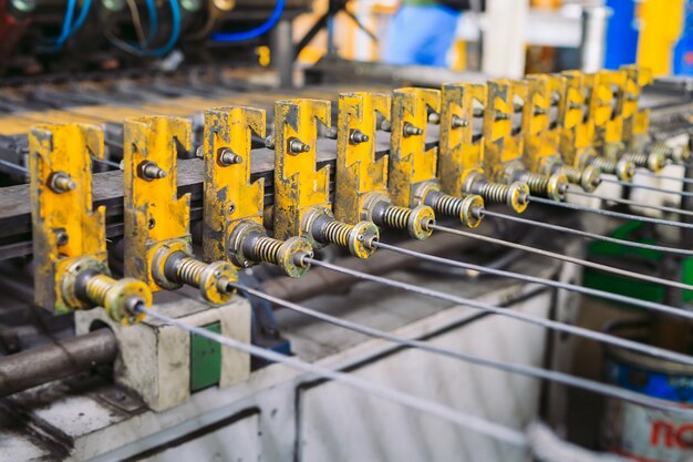 Alambre de acero de alimentación de metal en la máquina dobladora en la fábrica industrial