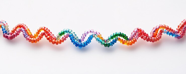 Foto alambre de cuentas de colores que forma un patrón ondulado en la superficie blanca