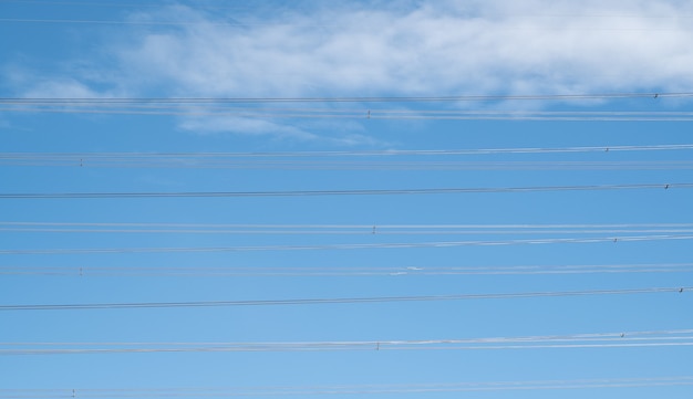 Alambre eléctrico abstracto en el cielo azul con nubes