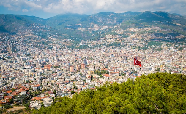 Alanya vista superior na montanha com a bandeira da turquia e fundo da cidade - marco de viagens bonita paisagem alanya turquia