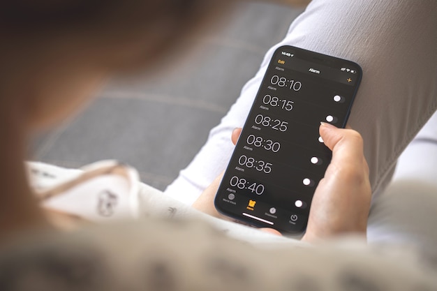 Alarma en el teléfono móvil para despertarse por la mañana, pantalla móvil con despertadores en primer plano