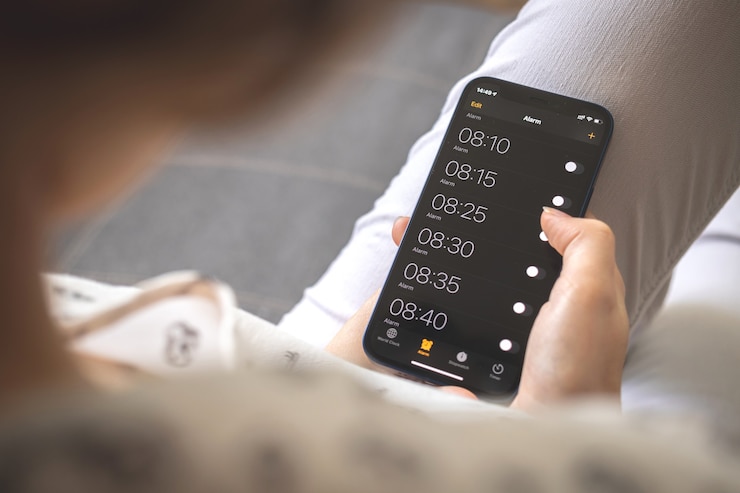 Foto alarma en el teléfono móvil para despertarse por la mañana, pantalla móvil con despertadores en primer plano