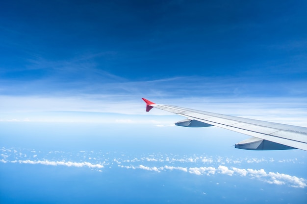 Alas de avión contra el cielo de nubes diminutas