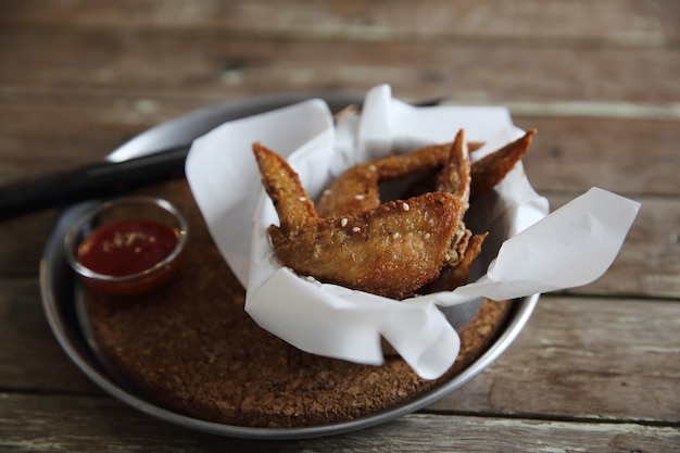 Alas de pollo sobre fondo de madera