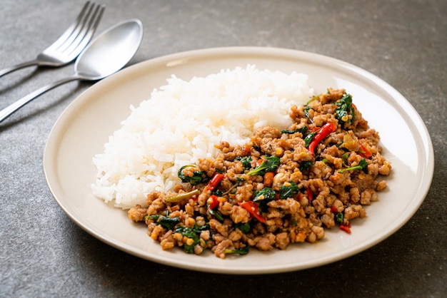 Albahaca tailandesa salteada con carne de cerdo picada sobre arroz cubierto