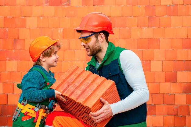 Foto el albañil hace que el constructor de mampostería trabaje con la capa de ladrillo hermanos en el trabajo niño pequeño reparando en el taller