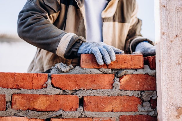 Foto albañil de pared de ladrillo de edificio de hombre