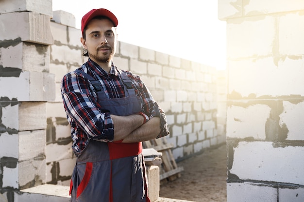 Albañil profesional confiado en el sitio de construcción