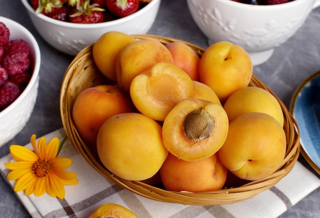 Albaricoques maduros en una cesta de mimbre fruta de verano