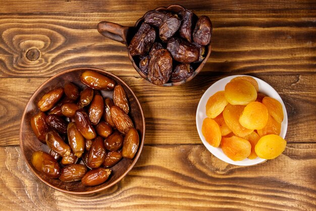 Albaricoques secos y dátiles en mesa de madera Vista superior