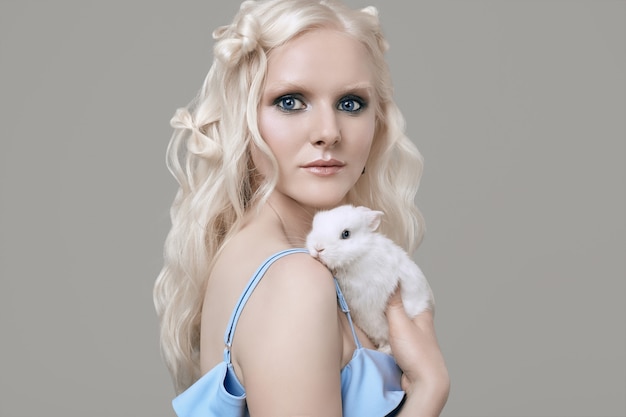 Albino menina loira elegante vestido posando com coelhinho fofo