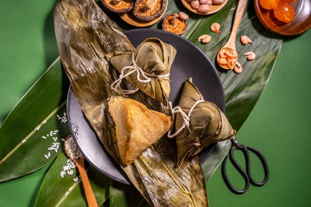 Albóndigas de arroz al vapor Zongzi sobre comida de fondo de mesa verde en el festival del bote del dragón duanwu concepto primer plano copia espacio vista superior plano