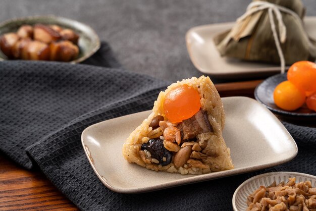 Albóndigas de arroz Zongzi para el Dragon Boat Festival sobre fondo de mesa gris oscuro con ingrediente