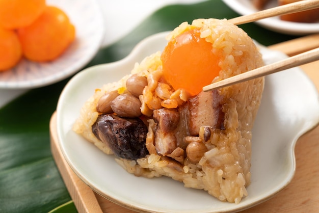 Albóndigas de arroz Zongzi para el Dragon Boat Festival sobre fondo de mesa de mármol brillante con ingrediente