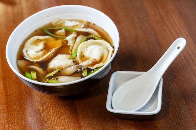 Albóndigas asiáticas servidas y preparadas como sopa con salsa de soja.