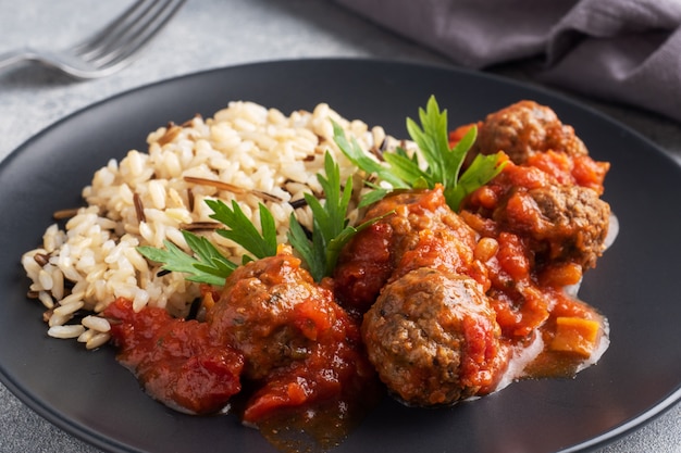 Albóndigas de carne y arroz integral en un plato.