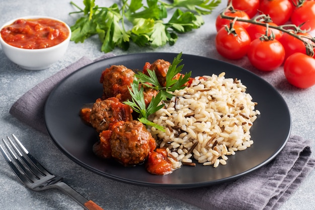 Albóndigas de carne y arroz integral en un plato.