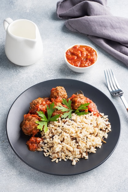 Albóndigas de carne y arroz integral en un plato.