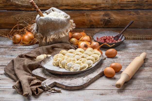 Albóndigas de carne cruda - pelmeni ruso en tabla de cortar