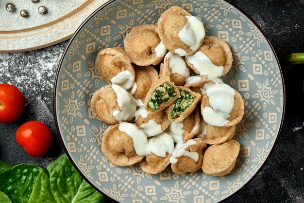 Albóndigas caseras con espinacas y pavo en un recipiente sobre una mesa oscura. Bolas de masa en una composición con verduras e ingredientes. Vista superior