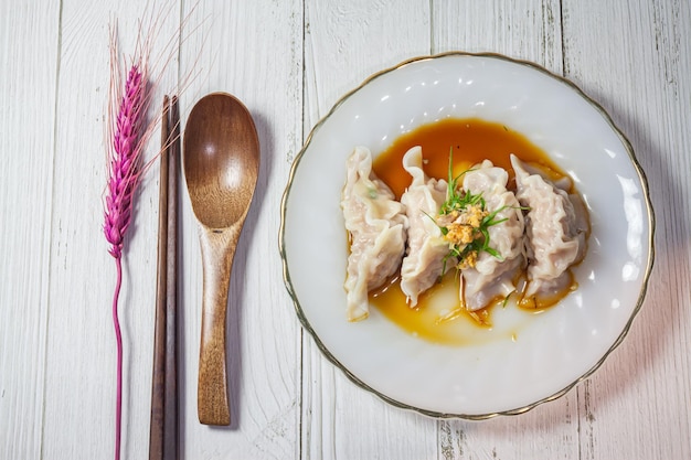 Albóndigas de cerdo Gyoza con salsa sobre fondo de madera vintage antiguo