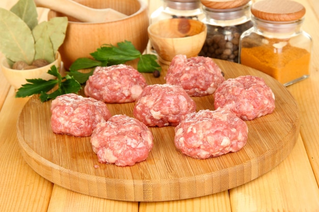 Albóndigas crudas con especias en mesa de madera