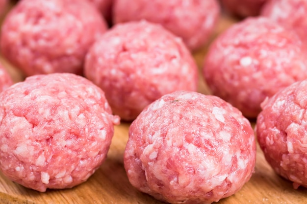 Albóndigas crudas de ternera y cerdo en una tabla de madera