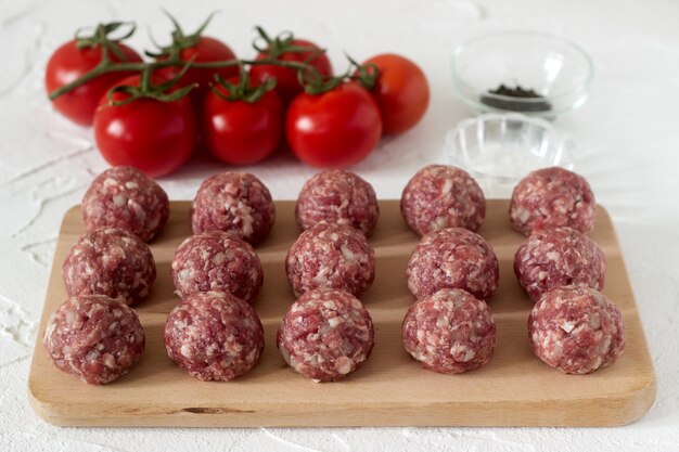 Albóndigas crudas, tomates y especias. Estilo rústico