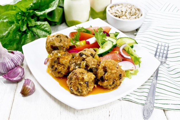 Albóndigas con espinacas y avena en mesa de madera