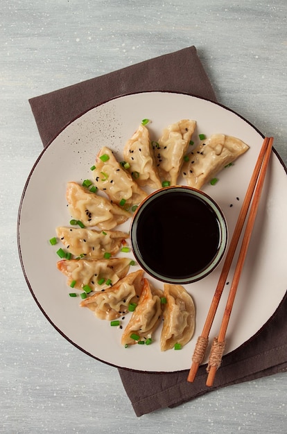 Albóndigas Gyoza japonesas fritas con salsa vista superior sin enfoque selectivo teñido de personas