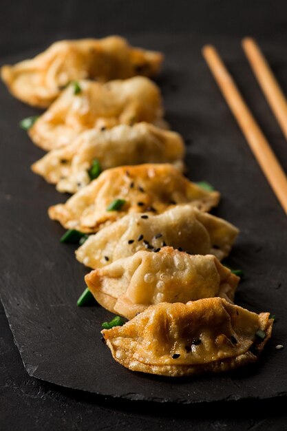 Albóndigas de gyoza japonesas fritas con salsa en una vista superior de fondo negro sin personas tonificadas selectivas