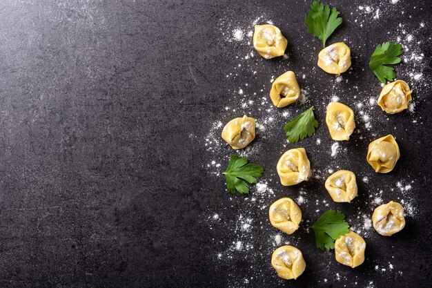 Albóndigas pelmeni crudas sobre negro