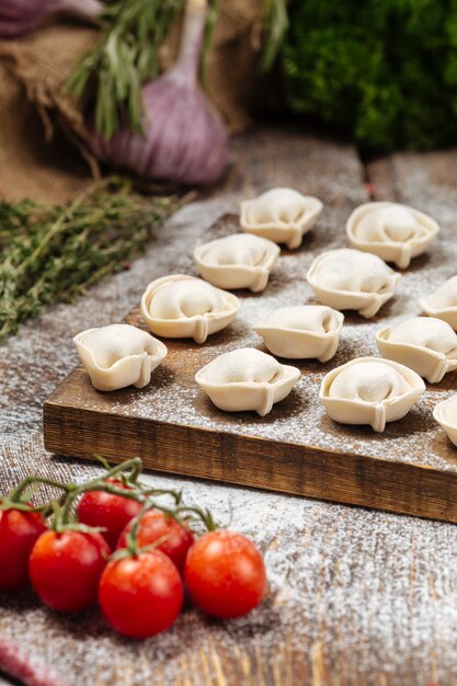 Albóndigas pelmeni semiacabadas sobre tabla de madera