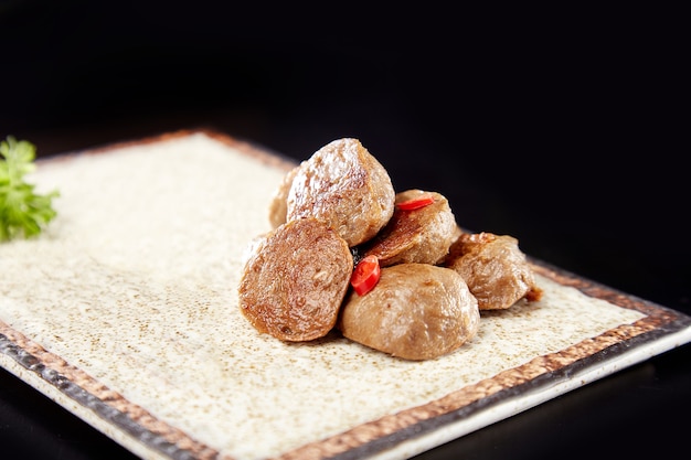 Albóndigas con plato sobre fondo negro