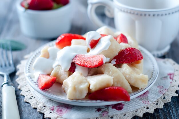 Albóndigas de queso cottage con fresas en la vista superior de fondo