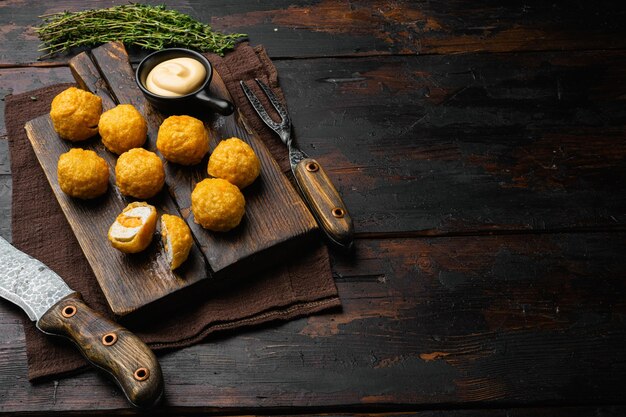 Albóndigas rebozadas sobre fondo de mesa de madera oscura antigua con espacio de copia para texto